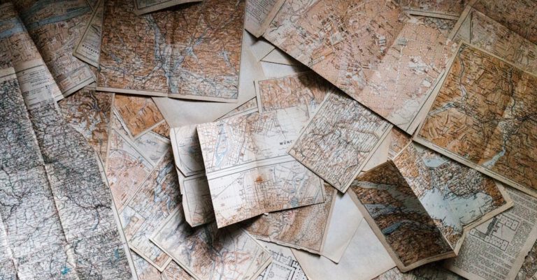 A collection of vintage maps scattered for exploring world journeys and discoveries.
